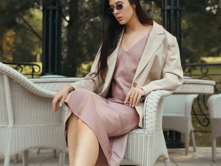 A woman wearing quiet luxury clothes and sitting on a chair in lazy luxury
