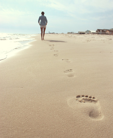 Women walking on the beach in South Carolina pondering her work in online therapy