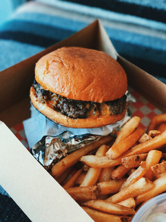 a burger and chips in a takeaway box