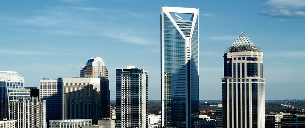 Charlotte, North Carolina skyline with modern skyscrapers and iconic architecture under a clear blue sky.
