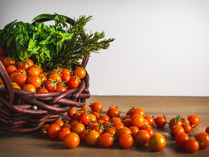 Basil and rosemary in a basket of tomatoes