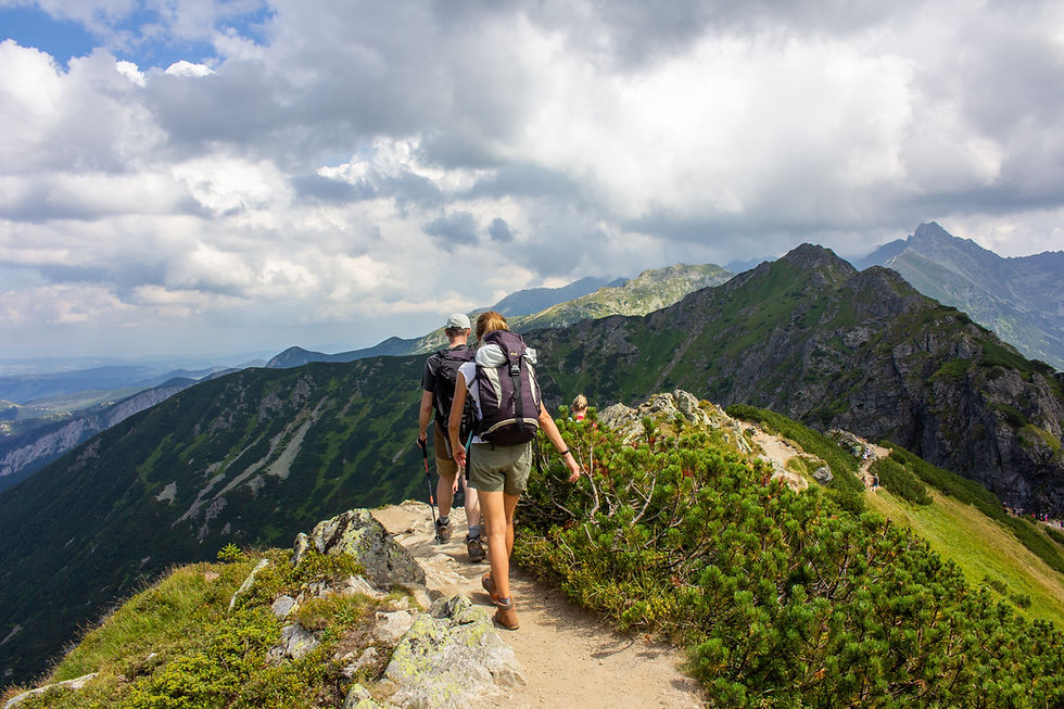 Male and female student hiking through the Lake District with backpacks