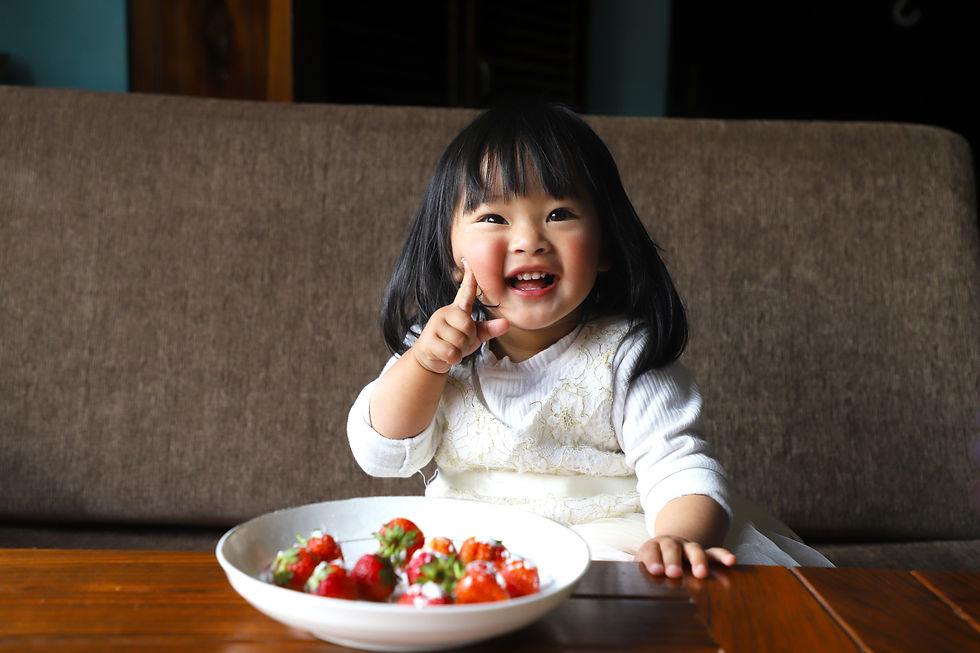 Happy toddler eating some strawberries