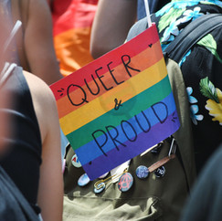 Rainbow pride flag that says, "queer & proud"