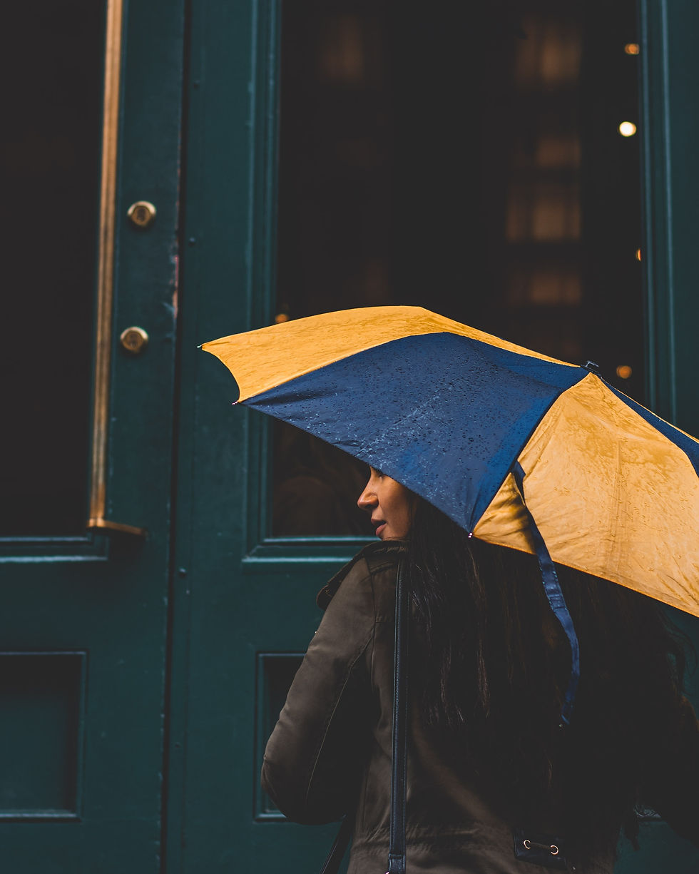 Girl standing under yellow umbrella processing childless grief and loss