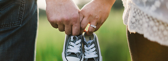 Couple holding baby shoes. Acupuncture for pregnancy care