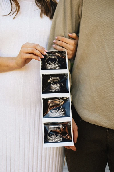 Couple holding ultrasound photos