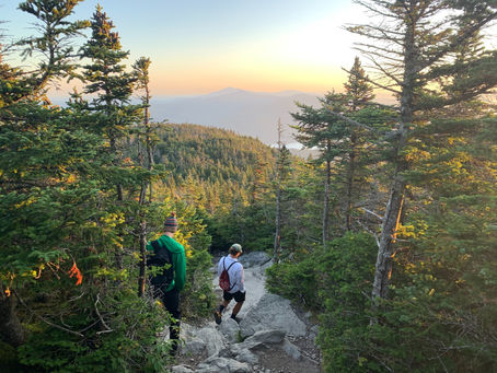 Group of outdoor athletes running together on a Vermont trail, representing the role of community, relationships, and play in work life play balance for athletes