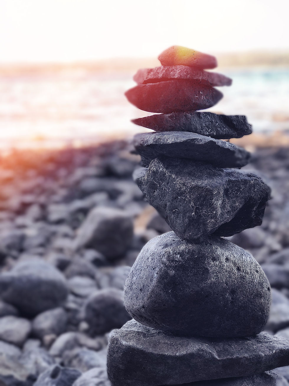 Stacked rocks balancing on a beach at sunset