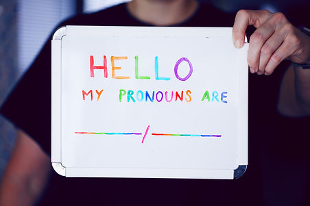 A person holds up a whiteboard with their hand that reads "hello my pronouns are" for Grit Therapy. Learn more about online LGBTQ therapy in Summit County, CO by searching LGBTQ therapist near me or contacting an LGBTQ therapist in Summit County, CO.