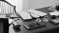 Black and white desk with papers and writing tools — midlife recalibration psychology