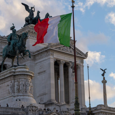 Italian flag flying over the Vittoriano monument in Rome, symbolizing Italian class action law reforms and justice.