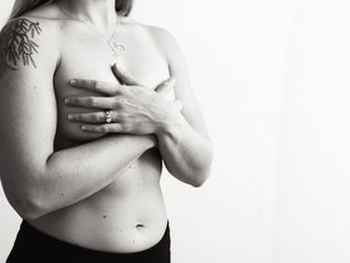 Close-up of a woman’s chest scar after mastectomy, soft light symbolizing healing and resilience.
