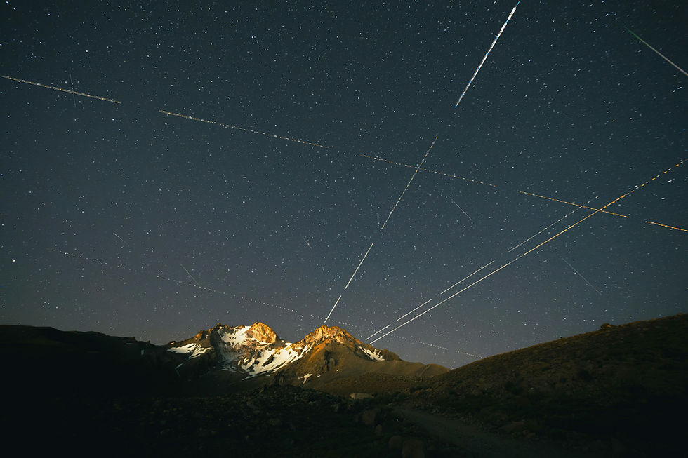 Long exposure night sky with light trails over a mountain, representing nationwide virtual grief support, community connection, and online therapy access across the U.S.