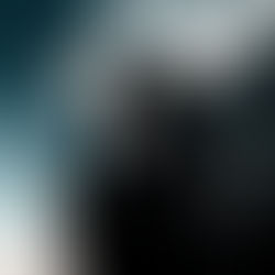 the silhouette of a man praying, sitting on a rock with a moody sunset background.