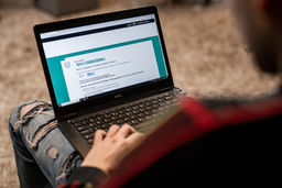 Personne remplissant un formulaire en ligne sur un ordinateur portable, illustrant le recueil du consentement numérique.