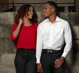 Black couple smile at each other holding hands after relationship therapy