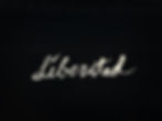 The image shows the word "Liberated" in white cursive on a black background, conveying a bold and freeing mood.