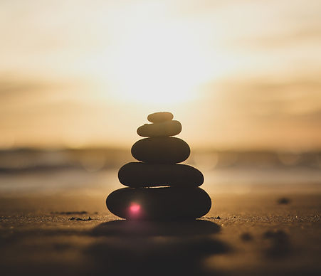 Balanced arrangement of four stones showcasing stability and peace in a serene setting.