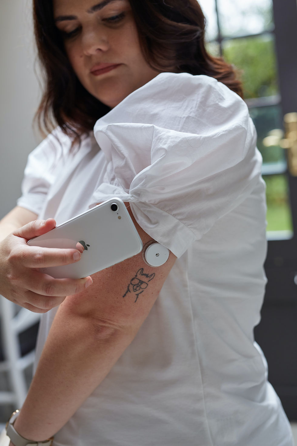 woman measuring her glucose levels with a continuous glucose monitor
