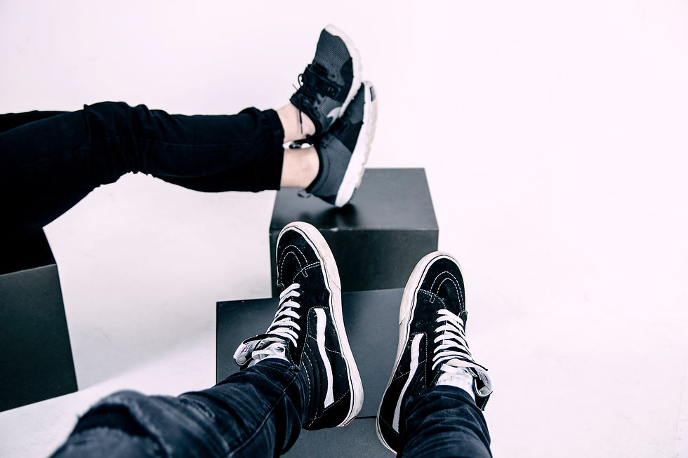 woman and man with feet in sneakers propped up on boxes