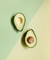 2 avocados on green background