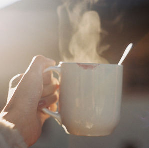 Mains tenant une tasse chaude, réconfort face aux émotions difficiles