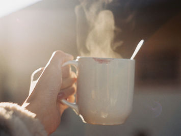 Mains tenant une tasse chaude, réconfort face aux émotions difficiles