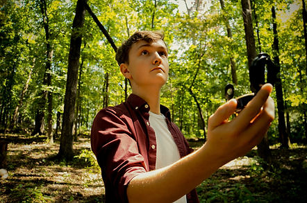 Young man consulting a GPS device in the woods