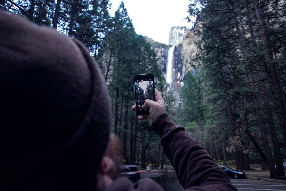 A person photographs Yosemite National Park on their phone