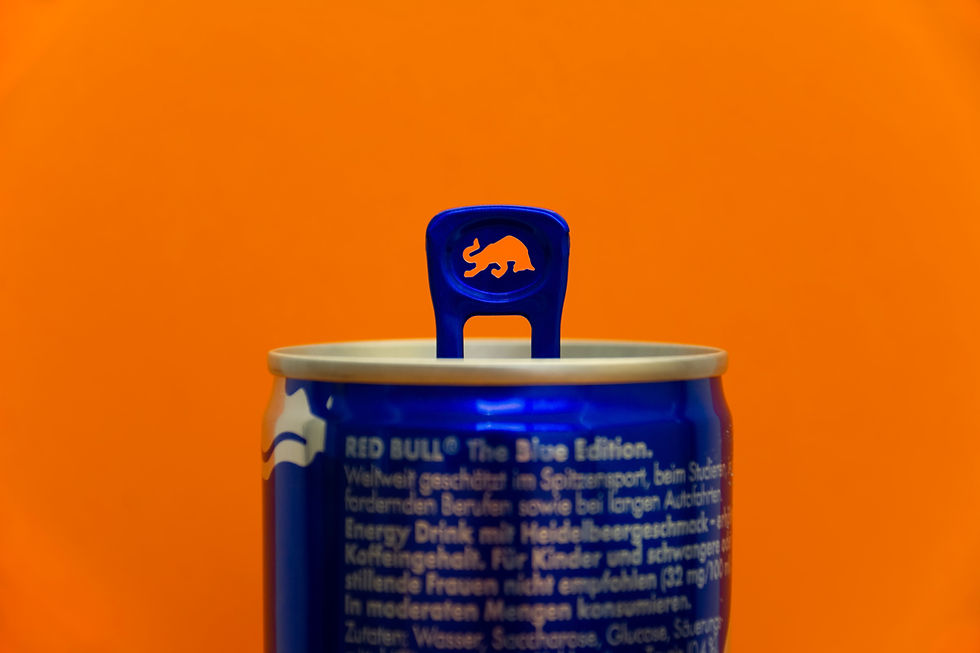A picture of the top half of a can of red bull drink against an orange background