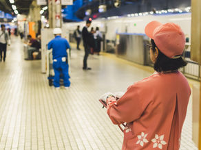 A woman in an orange outfit observes her team, embodying the role of a first-time boss learning to lead with confidence.