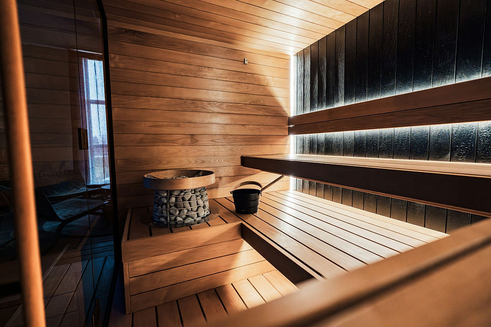 Modern dry sauna interior with wooden benches and sauna heater, commonly used in contrast therapy routines for recovery and wellness
