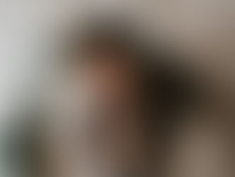 Mother and father kissing newborn in front of Christmas tree