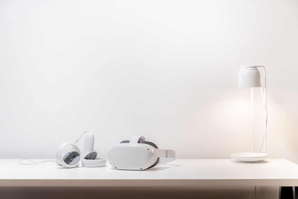 A meta quest 2 with two controllers on a table with a desk lamp.