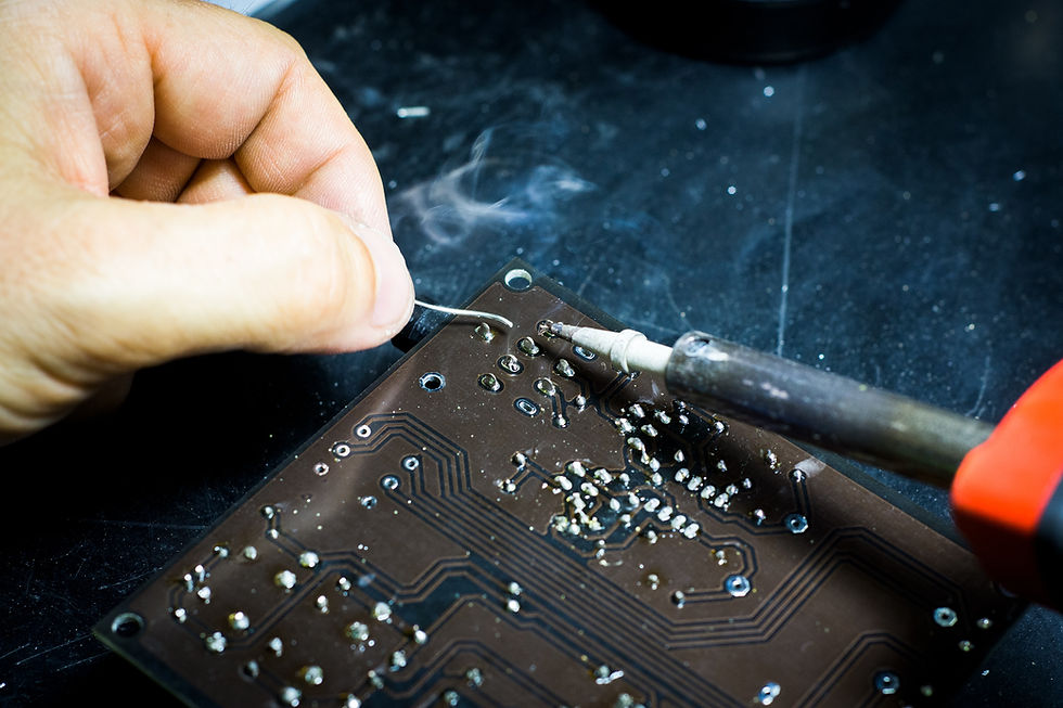 A man tinkering with a black circuitboard.