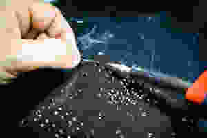 A man tinkering with a black circuitboard.