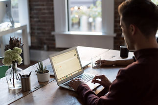 Vemos una persona de perfil utilizando un portatil encima de una mesa. Esta persona esta utilizando el software para el tercer sector y la digitalizacion, MIDUE