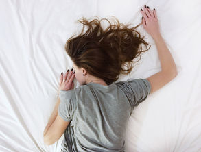 Woman lying in bed representing fatigue, mood changes, and PMS symptoms before menstruation.
