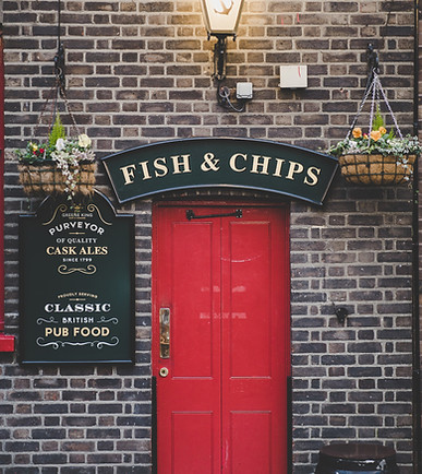 Traditional British pub with a red door serving classic Fish & Chips
