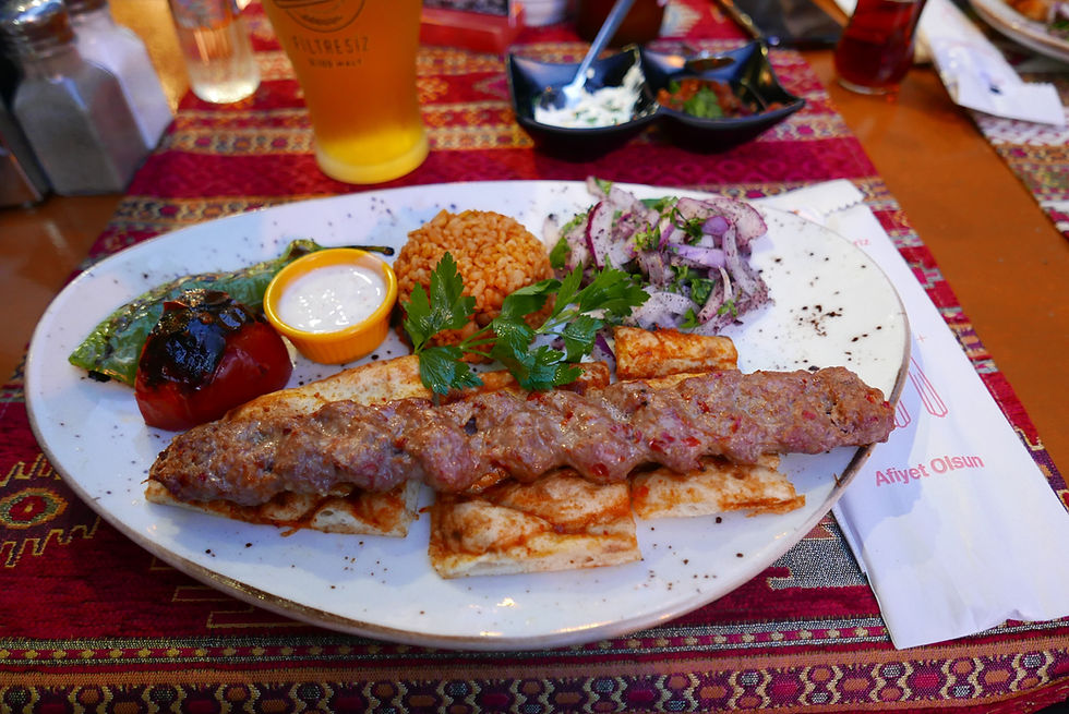 High angle view of a serving of grilled Adana kebabs with sides