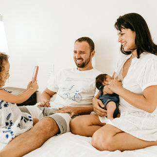Familie sitzt gemeinsam auf einem Sofa – gemeinschaftliche Räume erfüllen das Wohnbedürfnis nach Nähe und sozialer Verbindung.