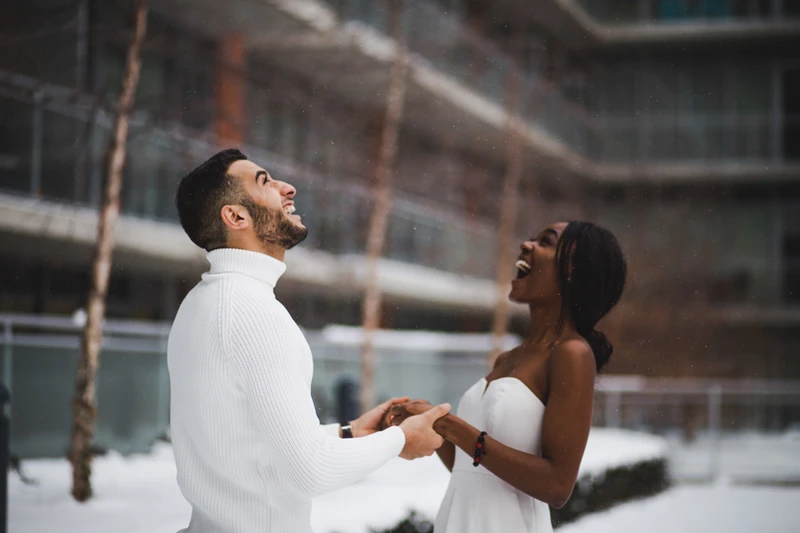 Couple laughing together dressed in white