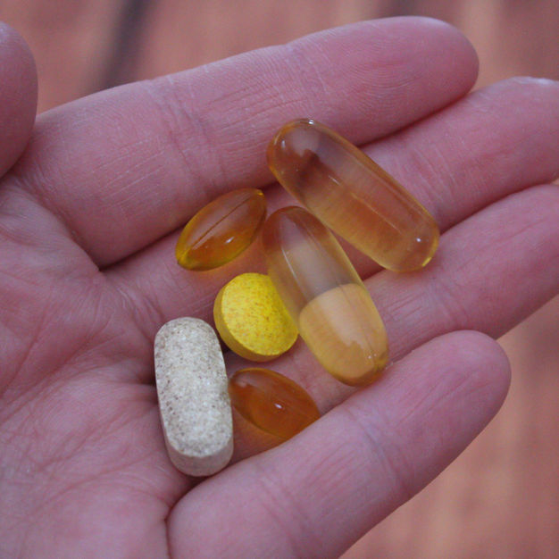 hand holding different pill medications for cancer treatment