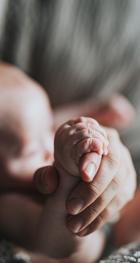 Zoom sur la main d'un bébé nourisson et de celle de son parent lors d'un atelier pour apprendre à masser bébé