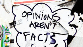 Street art reading "Opinions aren't facts" on a graffiti-covered wall