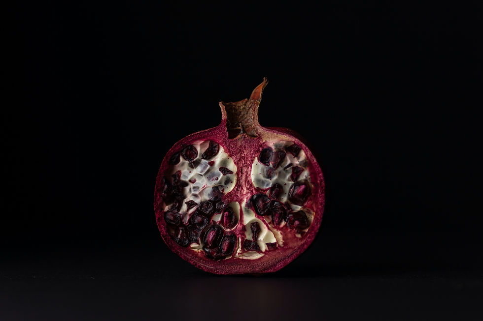 A photo of a pomegranate split in half against a black background.