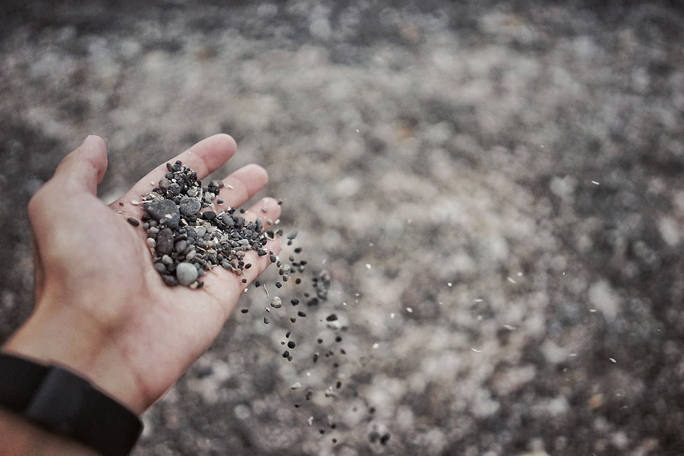 a person's hand holds a pile of gravel