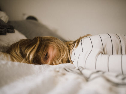 fatigue chronique jeune femme blonde allongée sur un lit