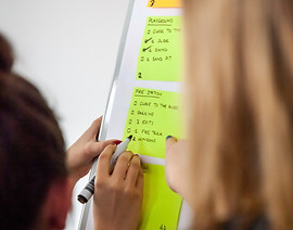 People writing on post-its on a white board